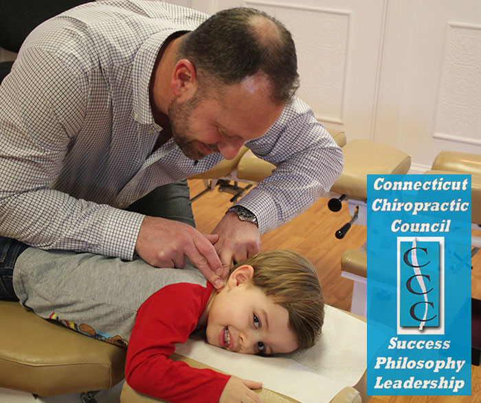 family chiropractor adjusting a young child on a chiropractic table